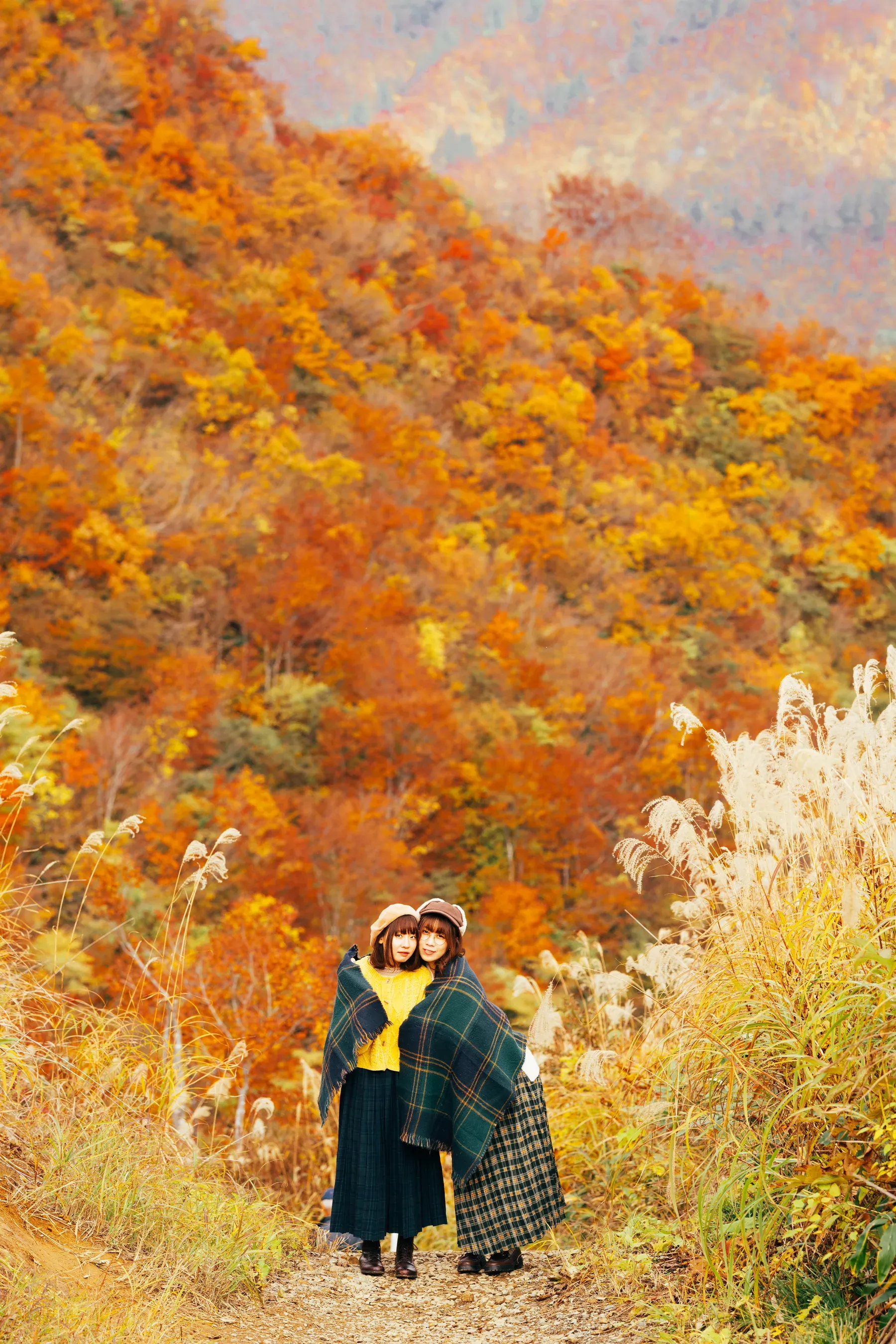 紅葉の斜面を背にした二人